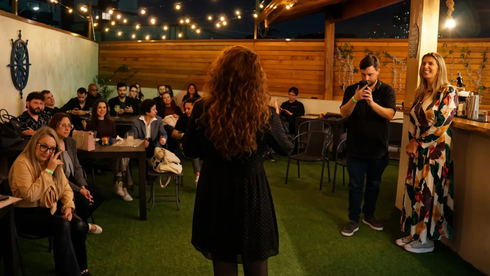 Ambiente do encontro com mesas e luzes no início da noite